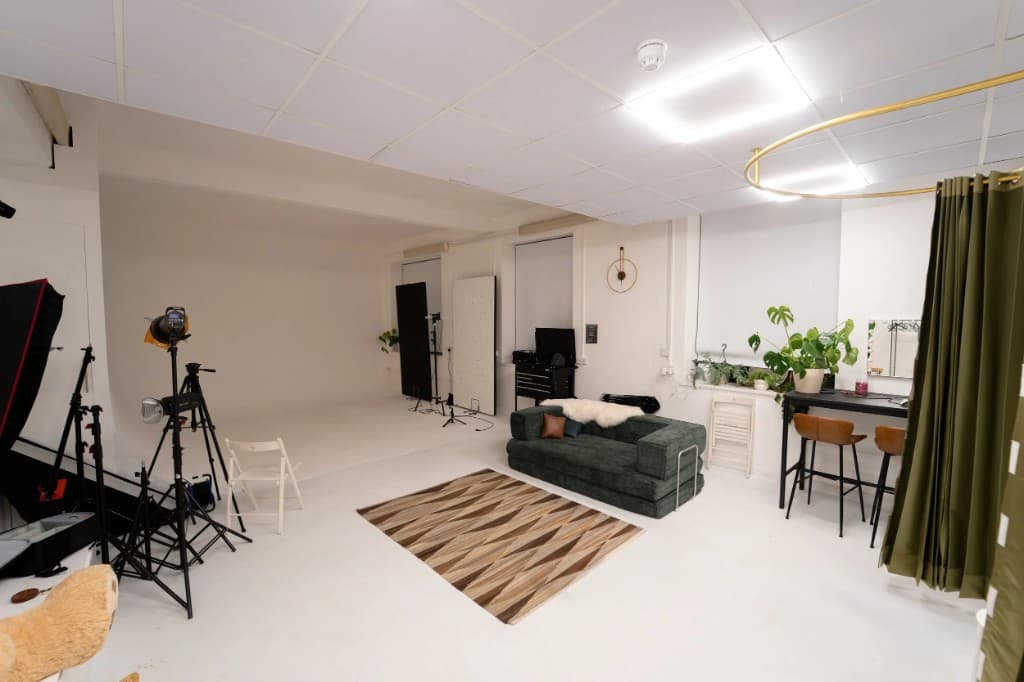 STU22 - bright white studio with infinity cove, green sofa, and lighting grid