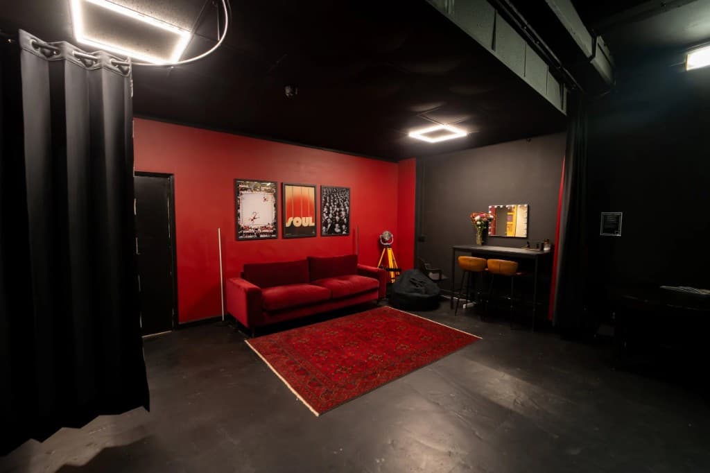 STU22 - red and black cinematic lounge with velvet sofa and vanity lights