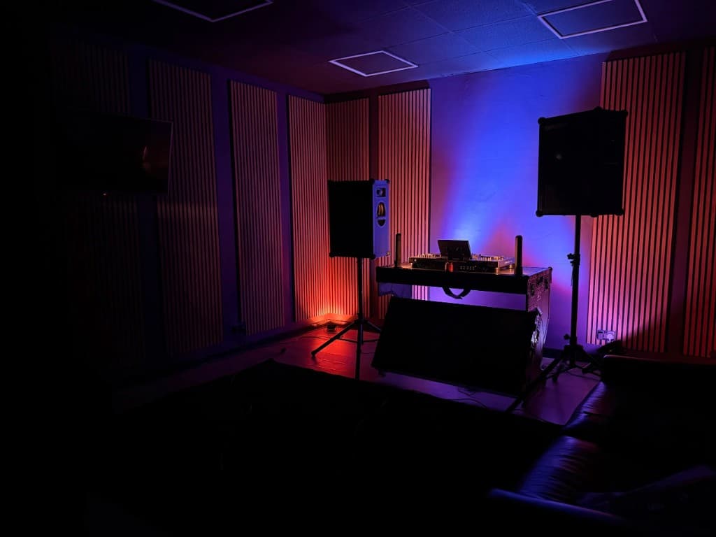 STU22 - DJ booth with red and blue mood lighting and PA speakers