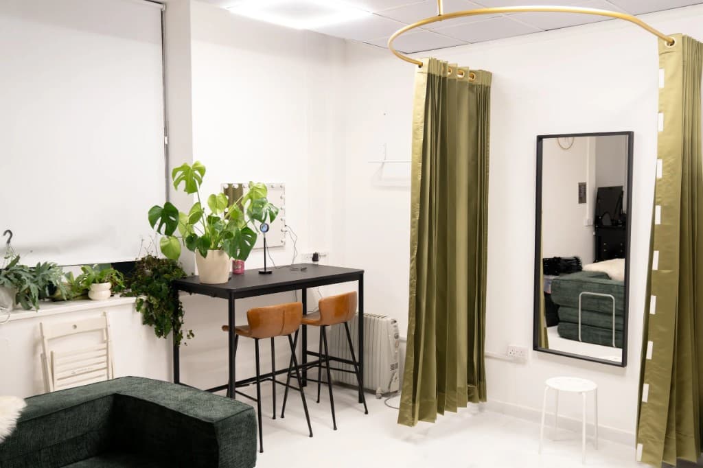 STU22 - white studio with high table, Monstera, and curtained changing area