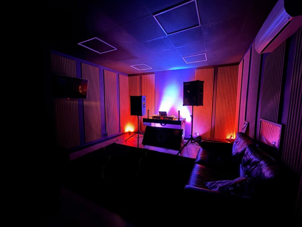 STU22 - DJ studio with wood-slat walls, decks, and leather sofa