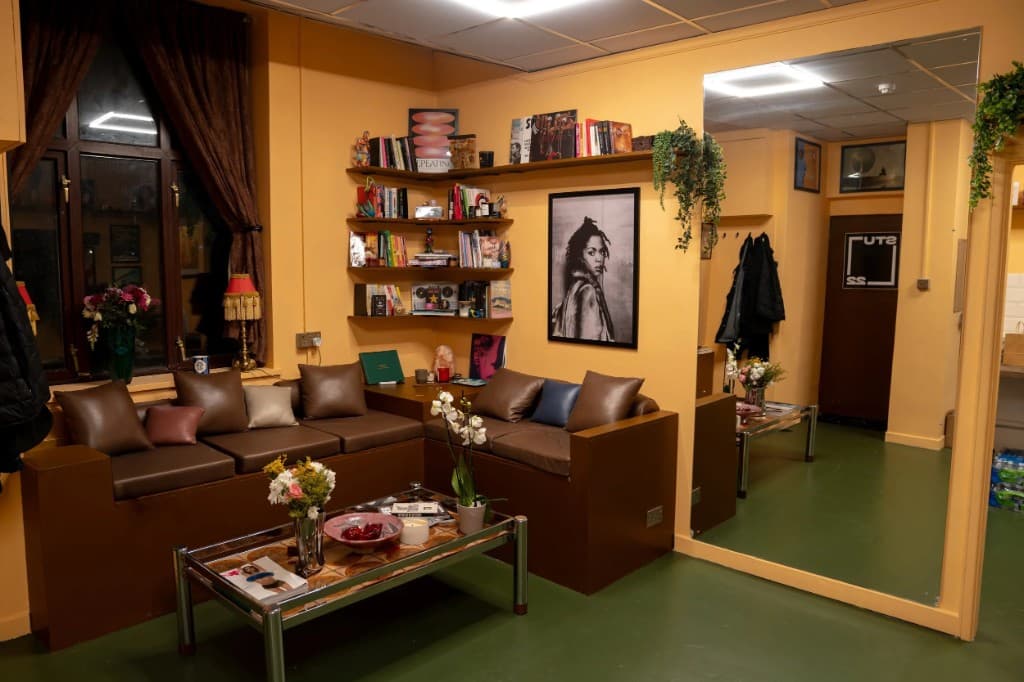 STU22 - warm creative lounge with leather sofa, shelves, and mirror